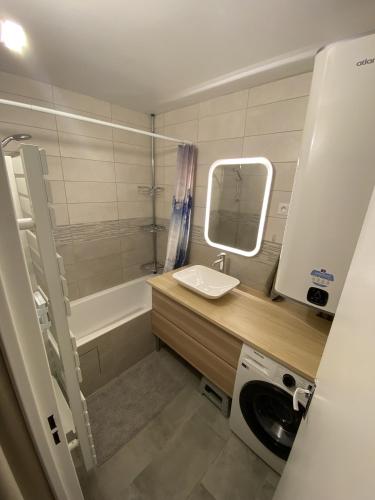 La petite salle de bains est pourvue d'un lavabo et d'une baignoire. dans l'établissement Le Chalain cosy proche centre ville, aux Rousses