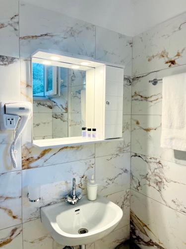 a bathroom with a sink and a mirror at Nefeli Studios in Vathi, Mani