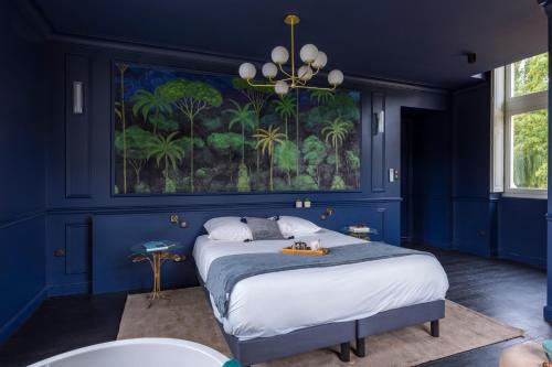 - une chambre bleue avec un lit orné d'une peinture murale dans l'établissement Château des Marais près de Chambord, à Muides-sur-Loire