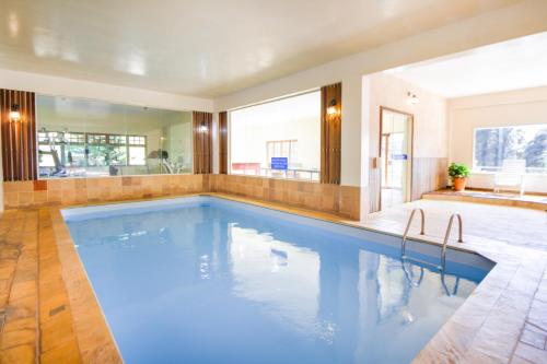 a large swimming pool in a room with a large mirror at VELINN Hotel Fazenda Fonte das Hortênsias in Santo Antônio do Pinhal