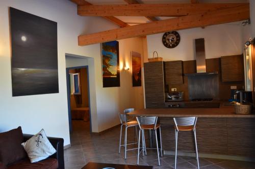 een keuken met een bar en krukken in een kamer bij Promesse de vacances réussies in Calcatoggio