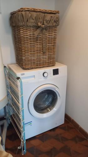 eine Waschmaschine mit einem Korb darüber in der Unterkunft Gîte des Hirondelles in La Noë