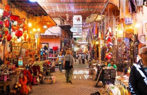 um grupo de pessoas caminhando através de um mercado de rua em riad cherif em Marrakech