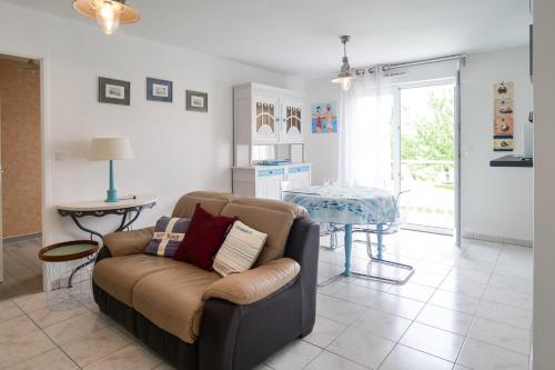 un salon avec un canapé et une table dans l'établissement Appartement dans résidence au calme avec piscine, à Les Sables-dʼOlonne