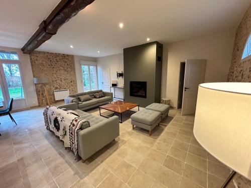 a living room with a couch and a table at Gîte de L'Oliviade - Campagne & Confort in Billancelles