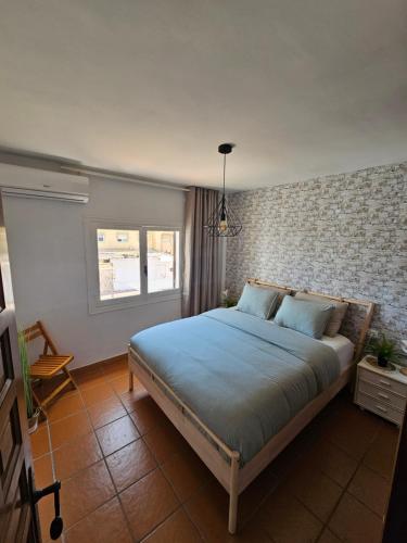 a bedroom with a large bed with blue sheets at Casa El Grande in Torrevieja
