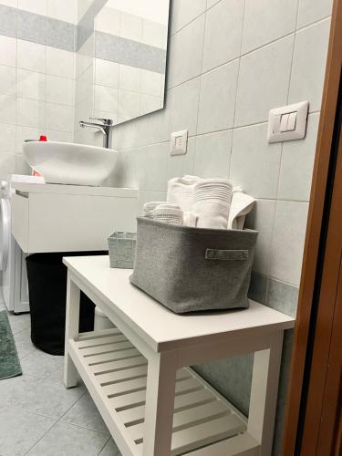 - Baño con lavabo y una cesta en una mesa en JACAM home free parking, en Albese Con Cassano