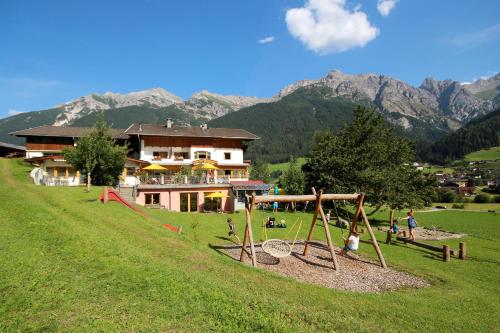 un parque infantil en un campo frente a una casa en Ladestatthof, en Neustift im Stubaital