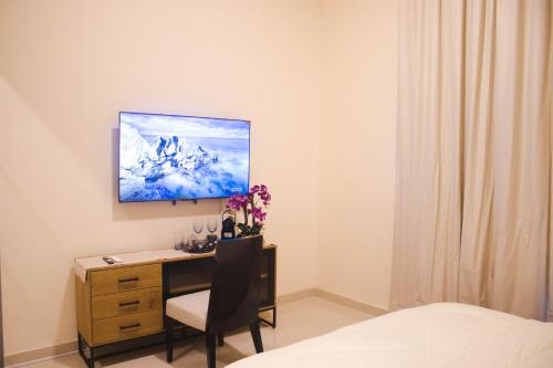 a bedroom with a desk with a chair and a tv on the wall at Studio Apartment in Abudhabi Zc in Abu Dhabi
