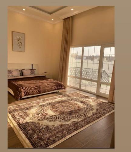 a bedroom with a bed and a rug on the floor at شاليه alrabe3 
