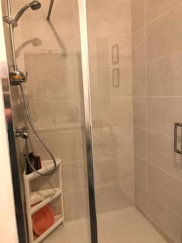 une douche avec une porte vitrée dans une salle de bain dans l'établissement T2 neuf au pied de la plage, à Saint-Pierre-Quiberon