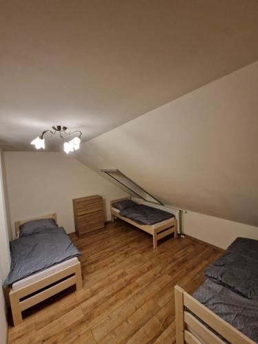 Cette chambre mansardée comprend deux lits et un escalier. dans l'établissement Sherpa's Hostel High Tatras, à Tatranska Strba