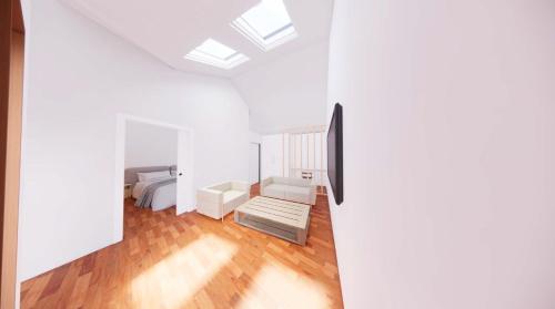 a bedroom with white walls and a ceiling with skylights at The Stables at Minstrel Court in Cambridge