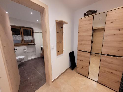 baño con aseo y armario grande de madera. en Gästehaus Eckau Ferienwohnungen en Ramsau