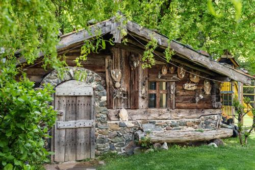 an old log cabin with a door and a window at Landhotel Latscherhof in Laces