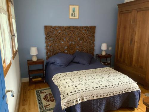 a bedroom with a large bed with a wooden headboard at Entre Pays Basque et Béarn in Lahontan