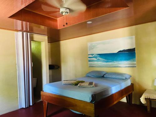 a bedroom with a bed with a painting on the wall at CABINA EL MANU in Golfito