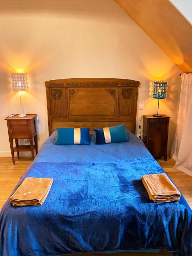 - une chambre avec un lit bleu et deux lampes dans l'établissement Gîte de la maison jaune - Comblanchien, à Comblanchien