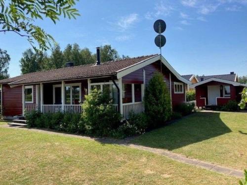 una pequeña casa roja con un patio de césped en Ferienhaus in Tibro mit Kleinem Garten, en Tibro