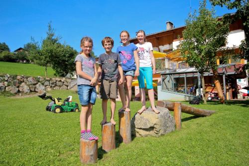 a group of people standing on wooden posts in a field at Ladestatthof in Neustift im Stubaital