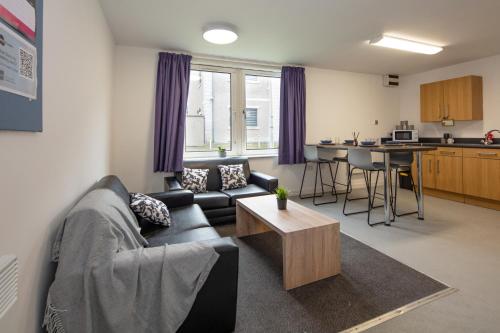 - un salon avec un canapé et une table dans l'établissement Charming Aberdeen Adult-Only Flats, à Aberdeen