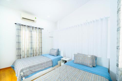 - une chambre avec 2 lits et une fenêtre dans l'établissement Tina Homestay 2 Đà Nẵng, à Đà Nẵng
