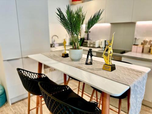 une cuisine avec une table, deux chaises et des plantes dans l'établissement RJO Apartments Chatham, à Brompton