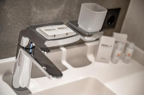 a sink with a faucet and a cup on it at Chalet Silvretta Hotel & Spa in Samnaun