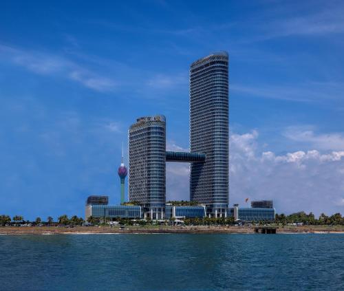 two tall skyscrapers in a city next to the water at ITC Ratnadipa, a Luxury Collection Hotel, Colombo in Colombo
