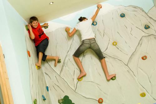 two people climbing a rock wall in a room at Ladestatthof in Neustift im Stubaital