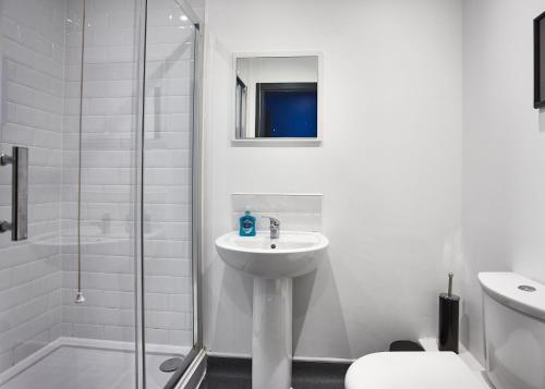 STARR SUITE 6 BEDS في ليفربول: حمام أبيض مع حوض ودش