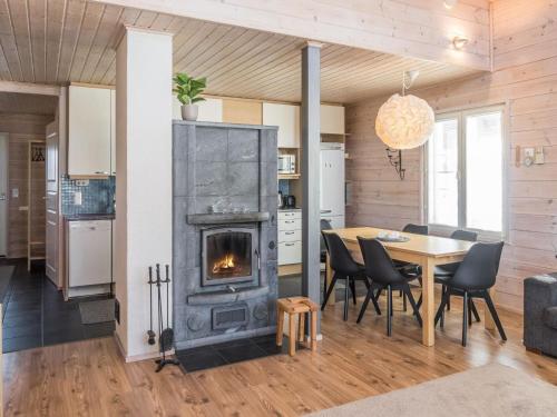 eine Küche und ein Esszimmer mit einem Kamin und einem Tisch in der Unterkunft Holiday Home Pikku-pölly by Interhome in Vuokatti