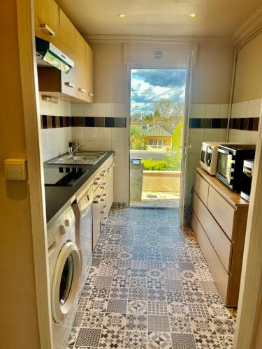 une cuisine avec un évier et une machine à laver dans l'établissement Grande maison proche Paris, à Chennevières-sur-Marne
