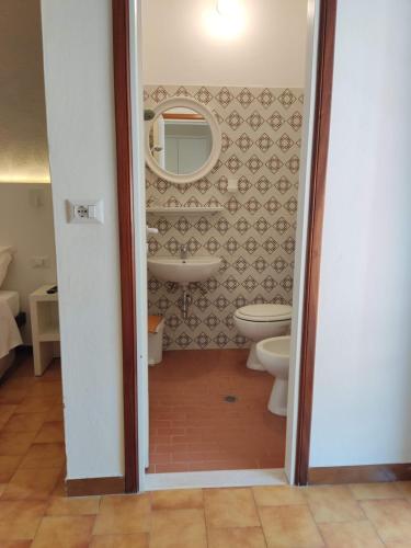 Albergo Conca d'Oro في ريميني: حمام مع مرحاض ومرآة