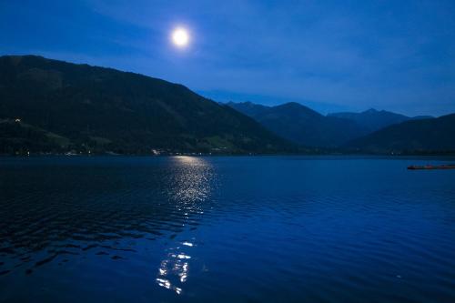a full moon rising over a lake at night at Oberhub am Kleinsonnberg in Taxenbach
