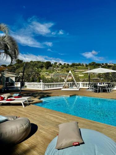 - une piscine avec des chaises et une table sur une terrasse dans l'établissement Superbe Villa à Antibes avec Piscine dans un quartier calme, à Antibes