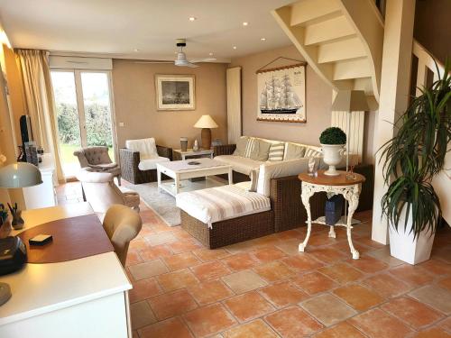 een woonkamer met een bank en een tafel bij Villa front de mer les Cordylines in Saint-Germain-sur-Ay