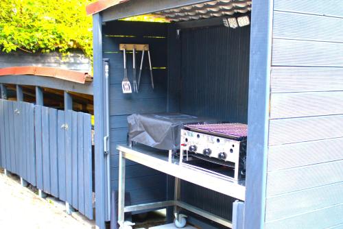 a blue shed with a grill in it at Gästehaus Ehringhausen 63 (Anno 1719) in Remscheid