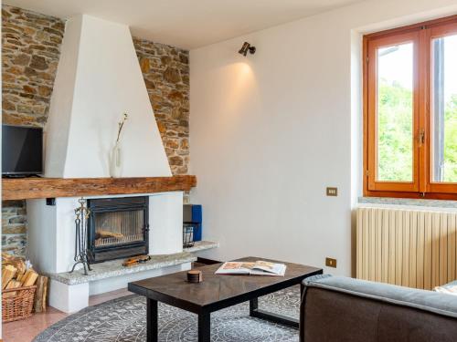 a living room with a fireplace and a table at Apartment Mezzo by Interhome in Vercana
