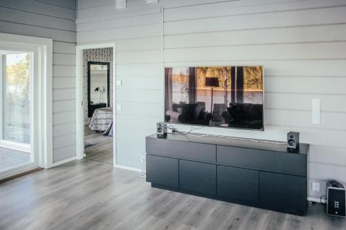 a living room with a tv on a wall at SleepWell Villa Hartola in Kirkkola
