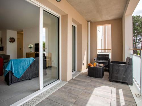 d'un salon avec des portes coulissantes en verre et une table. dans l'établissement Apartment Ty Héole by Interhome, à Pornic