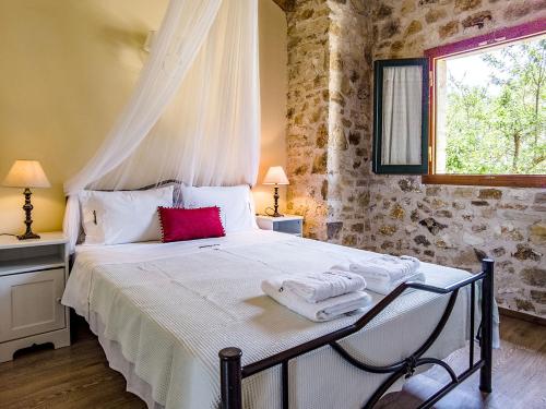 - une chambre avec un lit et des serviettes dans l'établissement Adamantia Traditional Village, à Bogdanátika