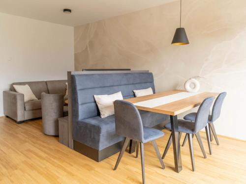 a dining room with a blue chair and a wooden table at Apartment be blue by Interhome in Mieming