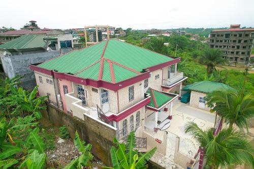 - une vue sur une maison dotée d'un toit vert dans l'établissement Ajieh Rest House, à Douala