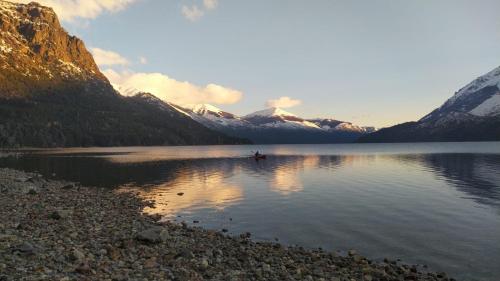 un barco en un lago frente a las montañas en Cabañas del Gutiérrez en San Carlos de Bariloche