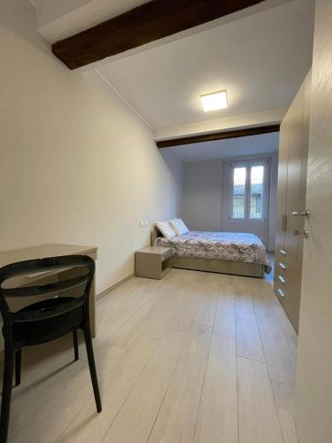 een slaapkamer met een bed, een bureau en een stoel bij Casa Paradiso in Bologna