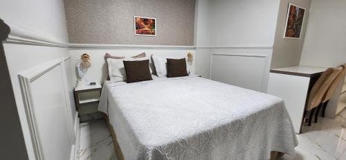 a bedroom with a bed with white sheets and pillows at Antonio's Hotel e Spa - Airport in Brasilia