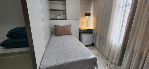 ブラジリアにあるAntonio's Hotel e Spa - Airportのベッドと窓が備わる小さな客室です。