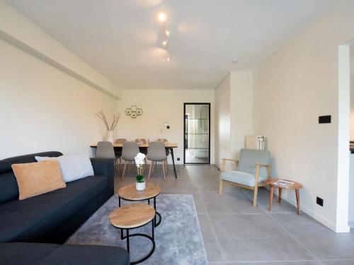 a living room with a couch and a table at Apartment 't zout by Interhome in Bredene