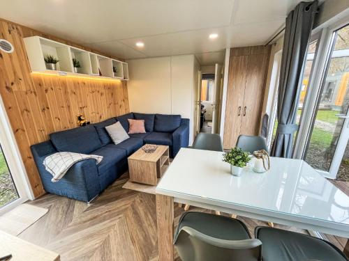 a living room with a blue couch and a table at Holiday Home Tiny Haus Villa Sunrise by Interhome in Riedenburg
